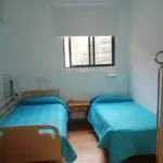 Habitación doble con ventana exterior y mesa auxiliar entre las camas