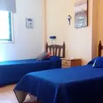 Habitación doble con dos camas individuales y mesilla compartida