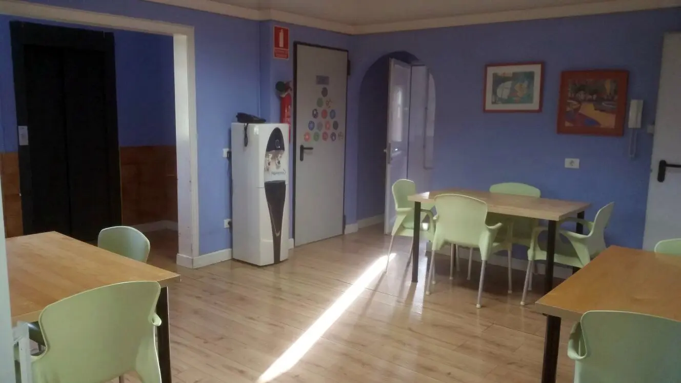 Comedor luminoso con mesas de madera y sillas adaptadas