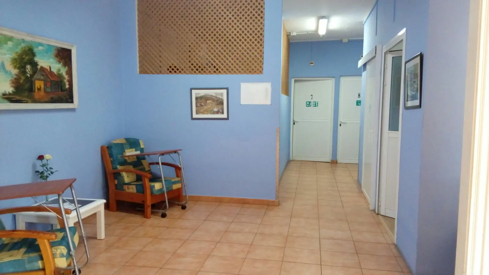 Pasillo con sillones de descanso y acceso a las habitaciones señalizadas